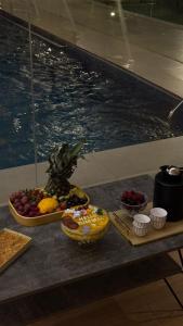 una mesa con fruta junto a una piscina en شاليه لينا الفندقيه, en Medina