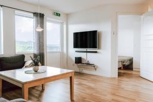 sala de estar con mesa y TV de pantalla plana en Ski in/Ski out | Sauna | WiFi | Terrace, en Lofsdalen