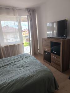 a bedroom with a bed and a flat screen tv at Noclegi Jak u Babci in Nowe Miasto +6 photos