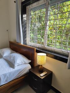 a bedroom with a bed and a lamp on a night stand at ArtCove Goa in Siolim +20 photos