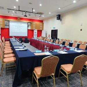 a conference room with tables and chairs and a screen at Hotel Seri Malaysia Alor Setar in Alor Setar