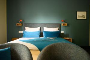 a bedroom with a bed with blue and white pillows at THE GREEN Rostock Apartment Hotel in Rostock