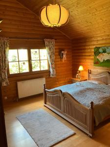 Un dormitorio con una cama grande en una cabaña de madera. en Landhaus An der Schafgasse, en Spittelstein