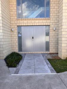 a building with a silver door on the side of it at Dream House 5 in Auckland