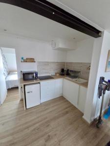 a small kitchen with white cabinets and a sink at L'appartement cosy du Portel in Le Portel