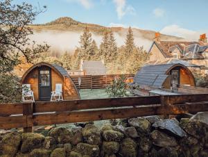a cabin in the woods with a fence at Strathyre Camping Pods in Strathyre