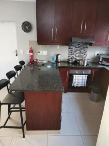 Una cocina con gabinetes marrones y una encimera. en Cosy 3 bedroom, en Cape Town