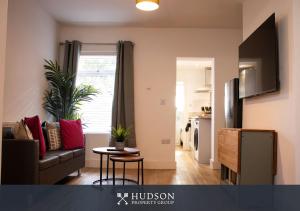オスウェストリーにあるCentral Oswestry 2 Bedroom Houseのソファとテーブルのあるリビングルーム