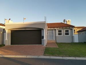 una casa con un garaje delante en Cosy 3 bedroom, en Cape Town