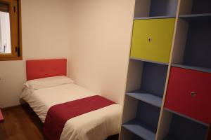 Habitación pequeña con cama y estante para libros en Fleur de Lis apartament, en Huéscar