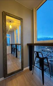 a mirror in a room with a table and a chair at Luxury apartment ЖК Вавилон Mountain View in Almaty