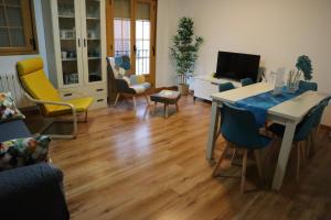 una sala de estar con una mesa y sillas en Fleur de Lis apartament, en Huéscar