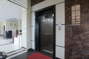 a hallway with a door and a red rug at Manjhi Stay in Tiruchchirāppalli
