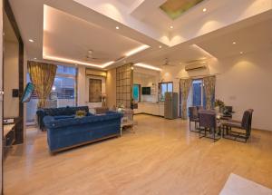 un soggiorno con un divano blu e un tavolo di Golden Villa 4 Bhk With Private Swimming Pool Centrally Located a Lonavala