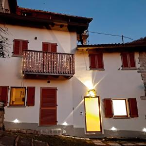 a white building with a balcony and a door at Family House Il Butto in Erve