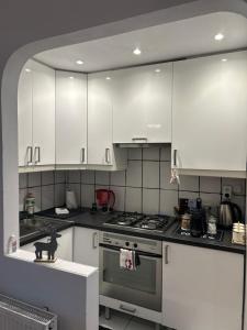 a kitchen with white cabinets and a stove top oven at The Stag Ultracentral OldTown Apartment in Braşov