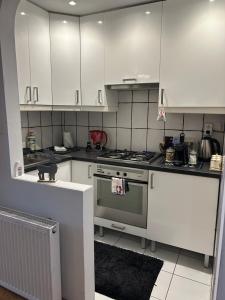 Una cocina con gabinetes blancos y una estufa. en The Stag Ultracentral OldTown Apartment, en Brasov 20 fotos más