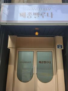 首尔Maison Veluna的建筑物门上方的标志