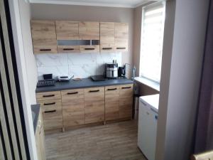 a kitchen with wooden cabinets and a counter top at Boguszów in Boguszów-Gorce