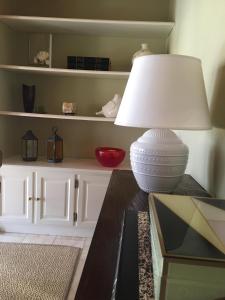 a white lamp sitting on a table next to a shelf at Apartamento Ruy Belo - Foz in Vila do Conde