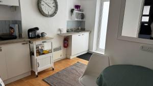 a room with a clock on the wall and a kitchen at SOBO Studio in Bournemouth +9 photos