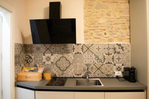 a kitchen with a sink and a tv on the wall at B&B Al Teatro Romano in Benevento