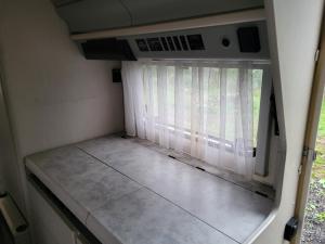 a small room with a window in a rv at Kempování s výhledem na hrady in Zdice