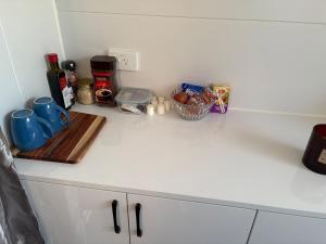 a white counter top with some food and drinks on it at Taree CBD Tiny backyard POD in Taree +1 photo