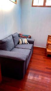 a couch in a living room with wooden floors at A paso del centro, mini cabaña cómoda in Puerto Natales