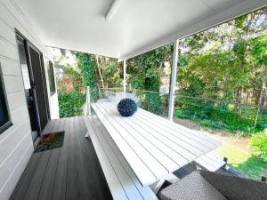 a porch with a bench and a vase on it at Seaside Escape - 5 BR 2 Kitchens in Port Macquarie