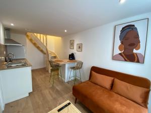 a living room with a couch and a kitchen at Havana Club - Numéro 1 in Niort
