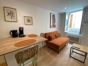 a living room with a table and a chair at Havana Club - Numéro 1 in Niort