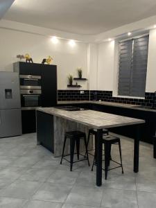 a kitchen with a table and some stools in it at Appartement de standing en centre ville in Orange