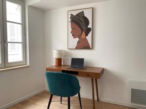 a desk with a laptop and a blue chair at Havana Club - Numéro 1 in Niort