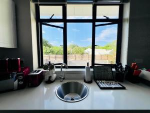 a kitchen counter with a sink and a window at The Yard Platinum Peak, Victoria Falls in Victoria Falls +53 photos
