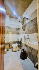 a bathroom with a toilet and a sink at Hotel Maa Aarti Palace in Ujjain