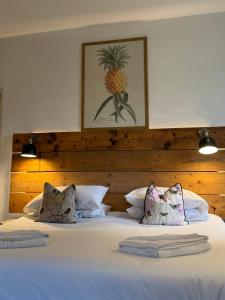 Una cama con dos almohadas y una imagen de una piña. en Hot Bath House, en Bath