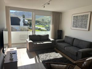 ヘルマナスにあるCentral Town Duplex with Pool, BBQ & Mountain Viewのソファとテーブルと窓のあるリビングルーム