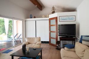 a living room with a couch and a tv at Sur la route des châteaux du Médoc in Blanquefort