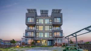 Un edificio alto con una mesa delante. en Goseong Littlesquare Oceanview Pension, en Goseong