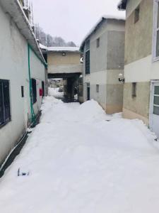 an alley covered in snow next to some buildings at Kings Hotel in Dargai