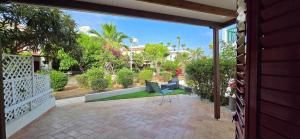 a patio with a table and a chair in a yard at Barefoot Beach House in Larnaka