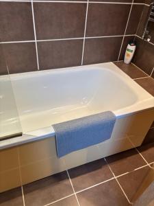 a bath tub with a blue towel on top of it at Thistle Tide 13 Nelson Street Largs KA308LN 1st Floor in Largs +15 photos