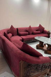 Una sala de estar con un sofá rojo y una mesa. en Entire villa near Medanta Hospital, en Gurgaon
