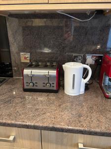 a toaster sitting on a kitchen counter next to a coffee mug at Thistle Tide 13 Nelson Street Largs KA308LN 1st Floor in Largs