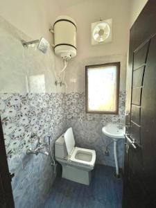 un baño con inodoro y lavabo en Entire villa near Medanta Hospital, en Gurgaon
