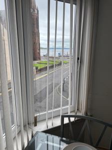 a room with a large window with a view of a street at Thistle Tide 13 Nelson Street Largs KA308LN 1st Floor in Largs