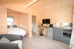 a bedroom with a bed and a kitchen in a room at Luxury Glamping Pod - Garthside Farm Holidays in Brampton