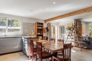 Una cocina con una mesa de madera y algunas sillas. en Chalet du Verney - Pied du Prarion - Sauna, en Les Chavants