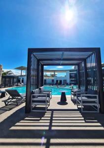 UrucaにあるCozy Apartment in San Jos Costa Rica with Stunning Sunset Viewsのラウンジチェア付きのプール、スイミングプールを提供しています。